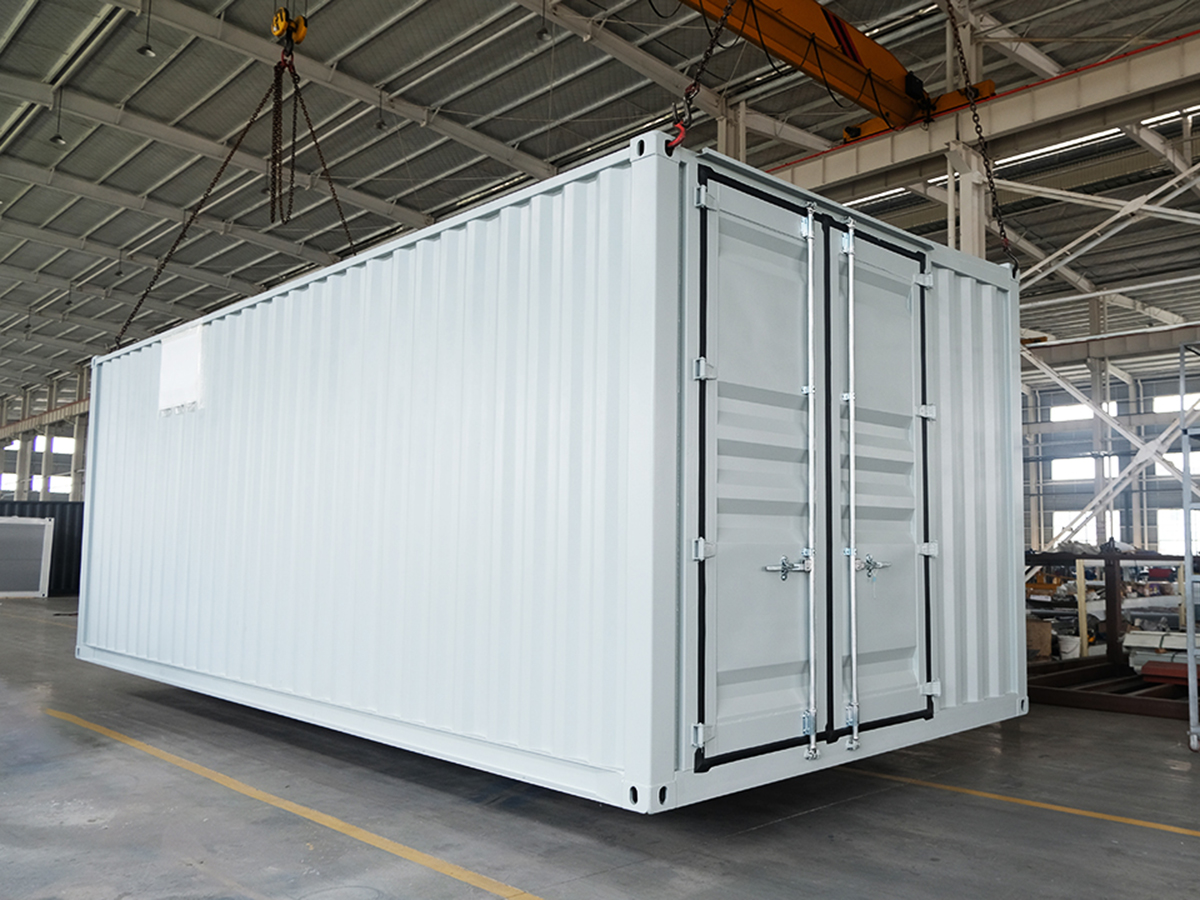 Wide white equipment enclosure with double end doors in a workshop
